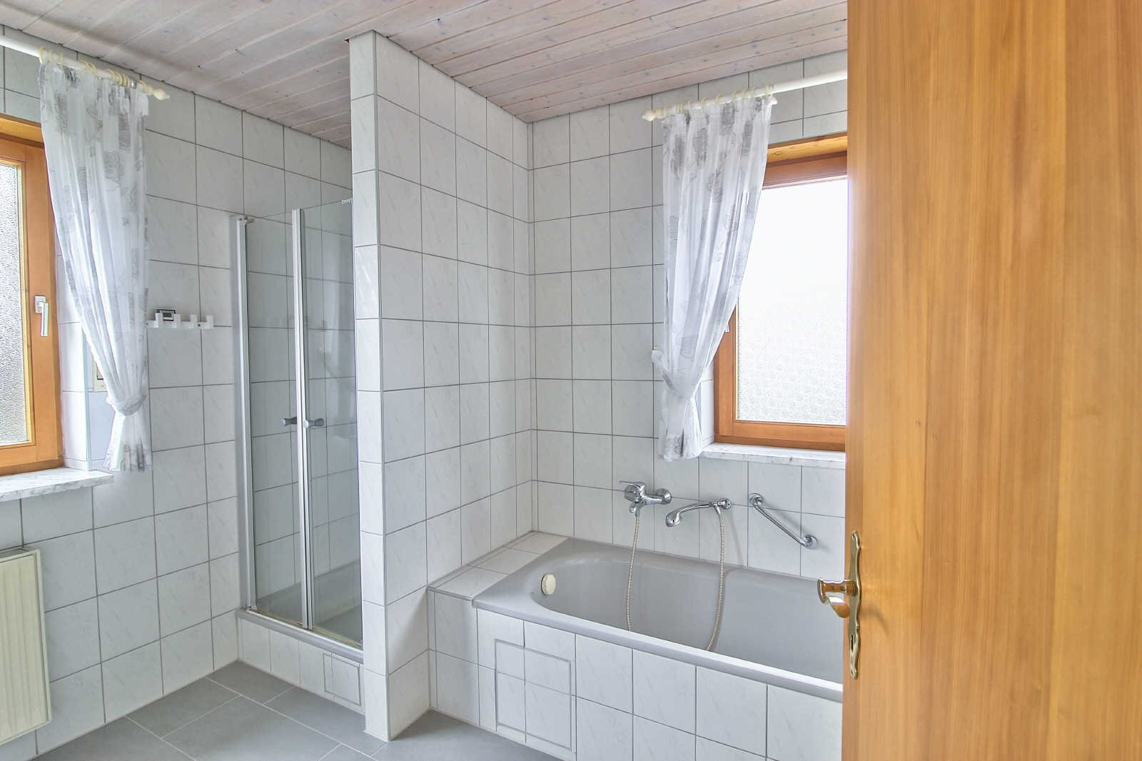 Gut belichtetes Bad mit Wanne und Dusche